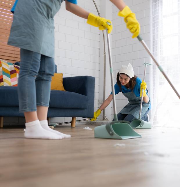 Cleaning service. Dark-haired woman wearing a white hat and yell Cleaning service. Dark-haired woman wearing a white hat and yellow gloves cleaning the floor